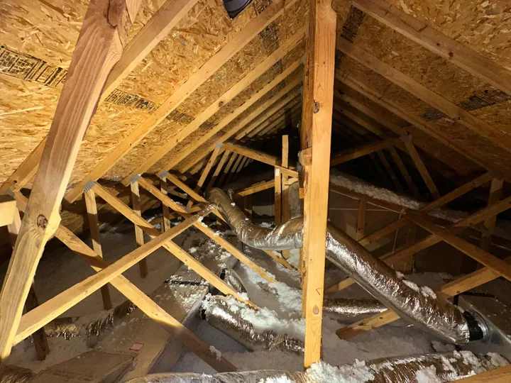 A wider view of the same finished attic, ducts and framing clear of debris.