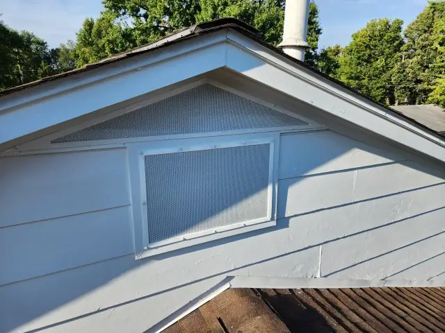 Finished gable vent with a perforated metal guard installed and painted to match.