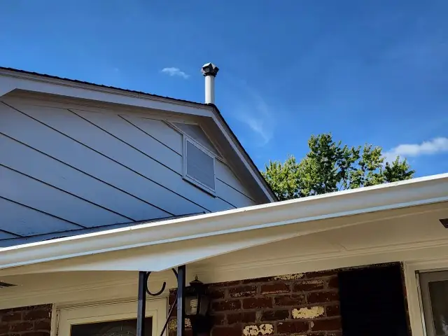 The repaired gable vent seen from the ground beside the front porch.