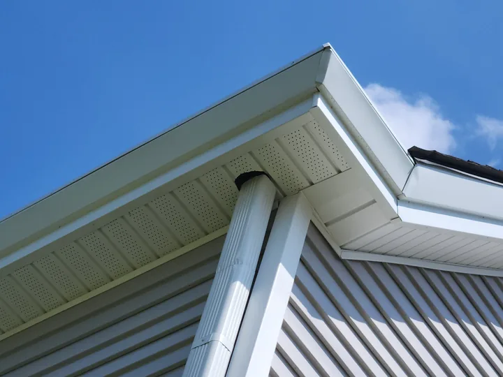 A finished soffit and gutter corner, clean, with the vented soffit closed off behind it.