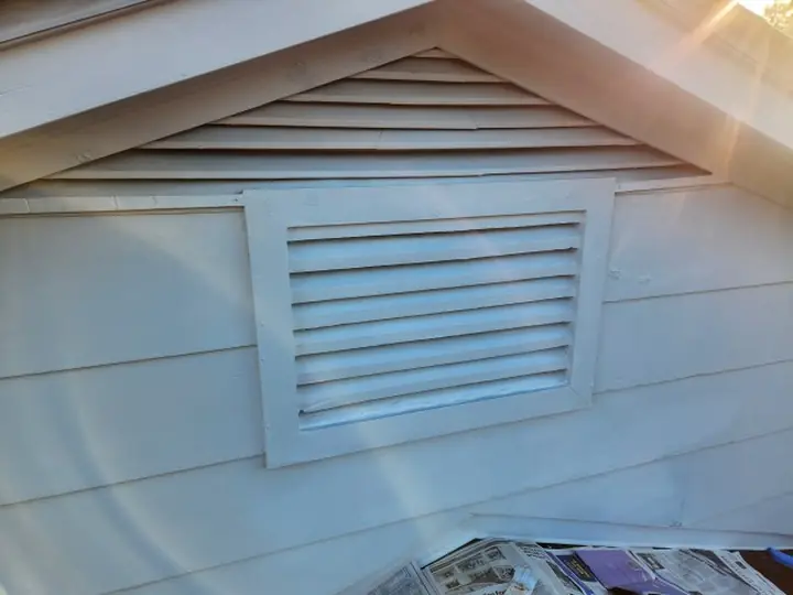 A gable vent cleaned, screw holes sealed and sanded, and repainted white.